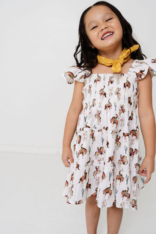 Alto Modas Girls Daphne Dress - Western
Child wearing a dress with horse print and a yellow scarf on a white background