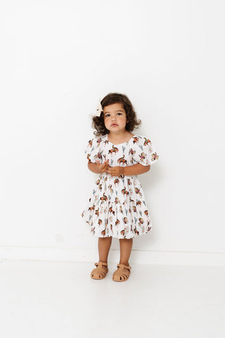 Alto Modas Girls Daphne Dress - Western
Young girl wearing a floral dress against a white background