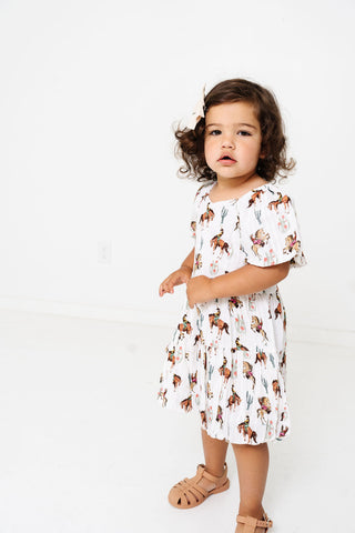 Alto Modas Girls Daphne Dress - Western
Child wearing a white dress with animal print on a white background