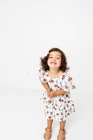 Alto Modas Girls Daphne Dress - Western
Child wearing a white dress with animal print on a white background