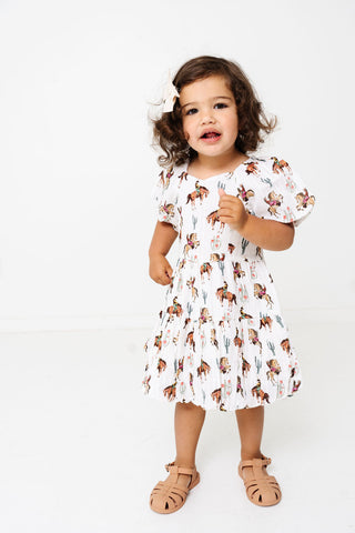Alto Modas Girls Daphne Dress - Western
Child wearing a floral dress on a white background