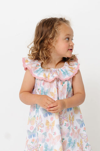 Alto Modas Girls Harper Dress - Butterflies
Young girl wearing a floral dress with ruffled sleeves against a white background