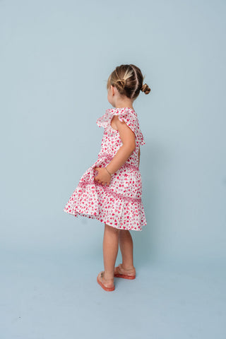 Alto Modas Girls Twirl Dress - Hearts Print
Young girl wearing a pink floral dress against a light blue background