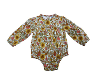 Alto Modas Maeve Baby Bubble - Sunflowers
A baby long-sleeve romper with a dense floral and sunflower print in yellow, orange, red, and brown on a white background.