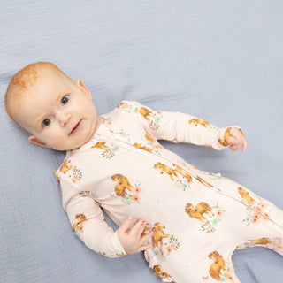 Angel Dear 2 Way Ruffle Back Zipper Footie - Pink Ponies
Baby wearing a long-sleeve onesie with animal print on a blue blanket