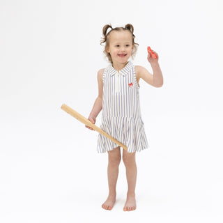 Angel Dear Polo Dress with Cartwheel Short - Baseball Stripe
Young girl in a striped dress holding a ruler on a white background