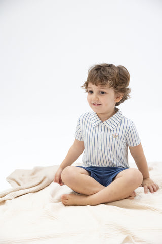 Angel Dear Polo Shirt & Everyday Short Set - Baseball Stripe
Child wearing a striped shirt and shorts sitting on a white blanket.