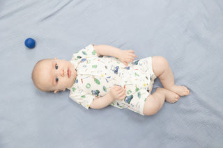 Angel Dear Polo Shortie - Golf Things
Baby lying on a blue blanket with a blue ball nearby