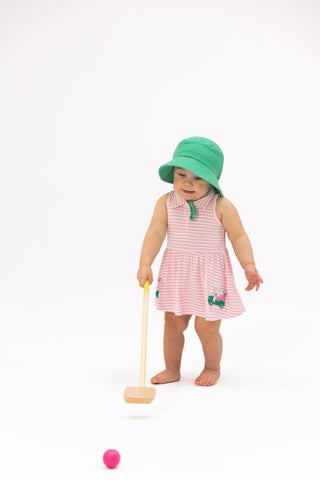 Angel Dear Polo Tennis Dress - Striped Golf
Child wearing a pink dress with green accents and a matching hat, holding a wooden toy on a white background.