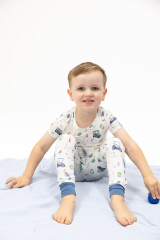 Angel Dear Short Sleeve Loungewear Set - Golf Things
Child wearing a patterned onesie sitting on a white blanket