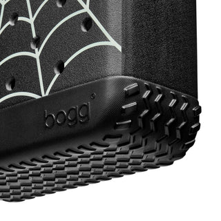 Bitty Bogg® Bag - Itsy Bitsy Glow in the Dark
Close-up of a black Bogg tire with a rugged treaded bottom edge and a white spiderweb pattern on the side, shown against a white background.