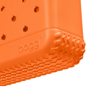 Bitty Bogg® Bag - Pieces of Pumpkin
Close-up of the corner of an orange Bogg storage container, showing the textured treaded bottom edge and the embossed Bogg logo on a white background.