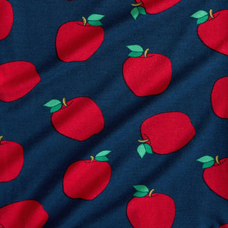 Posh Peanut Lilian Collared Twirl Dress Red apples with green leaves on a blue fabric background