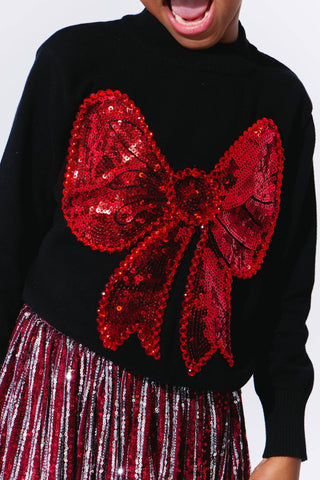 Lola and The Boys Big Bow Sweater
Black sweater with a large red sequin bow and striped skirt