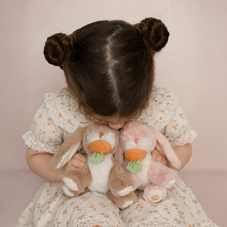 Olli Ella Binky Bunny - Hop
Olli Ella Binky Bunny - Dot
Child holding two plush bunnies against a pink background