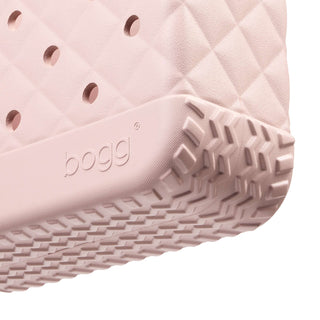 Bitty Bougie Bogg® Bag - Quilted Rose Petal
Close-up of a pink rubber sole with tread pattern and 'bogg' branding on a white background