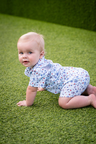 BlueQuail Clothing Co Polo Short Sleeve Romper - Stars & Stripes
Baby crawling on a grassy surface wearing a patterned outfit.