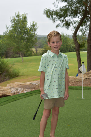 BlueQuail Clothing Co Polo Short Sleeve Shirt - Dogwood
Person on a golf course holding a golf club with trees and grass in the background