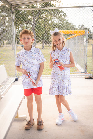 BlueQuail Clothing Co Polo Sleeveless Dress - 7th Inning StretchTwo children in matching outfits standing in front of a sports net.
