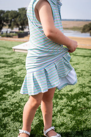 BlueQuail Clothing Co Polo Sleeveless Dress - Sherbet Stripe
Child wearing a striped dress standing on grass with a scenic background