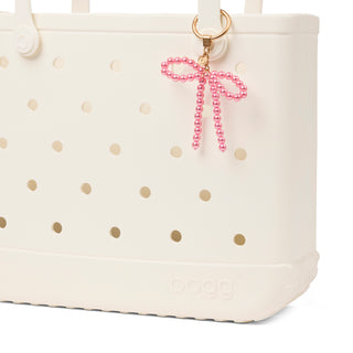 Bogg'd & Charmed - Pink Pearl Bow
White polka dot bag with a pink beaded bow charm on a white background