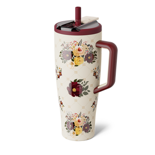 Brumate Era Flip 40oz - Quilted Florals
A tall insulated travel tumbler with a floral print on a cream background, featuring a dark red handle and lid, and a small white card insert near the lid.