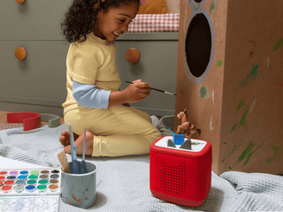 Tonies Character - Disney and Pixar Toy Story 5: Bullseye
Child playing with a red toy and a cardboard box in a room with a checkered blanket.