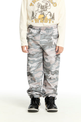 Chaser Desert Camo Jogger
Person wearing a graphic sweatshirt and camouflage pants on a white background