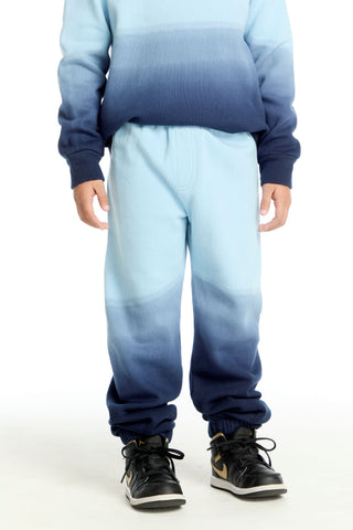 Chaser Malibu Blue Ombre Jogger
Person wearing a blue and gray gradient outfit with matching shoes on a white background