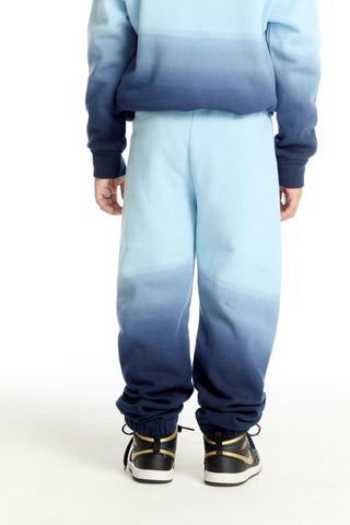 Chaser Malibu Blue Ombre Jogger
Person wearing a blue and gray gradient outfit with matching shoes on a white background