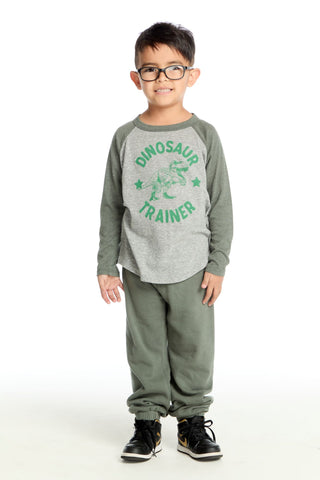 Chaser Dinosaur Trainer Long Sleeve Tee
Child wearing a gray long-sleeve shirt with 'Dinosaur Trainer' text and green pants on a white background