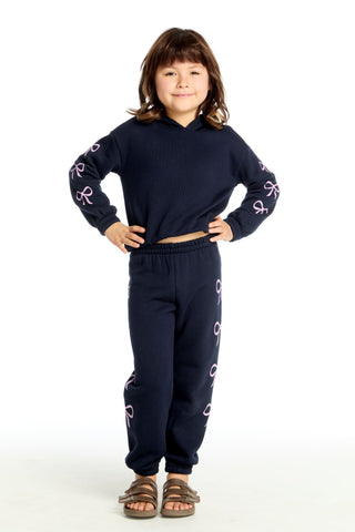 Chaser Semi Cropped Shirred Stormy Bows Hoodie Pullover
Child wearing a navy blue outfit with pink designs on a white background