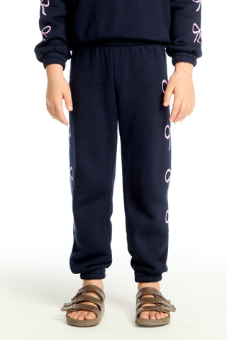 Chaser Shirred Easy Stormy Bows Sweatpant
Navy blue sweatpants with white patterns worn by a person on a white background