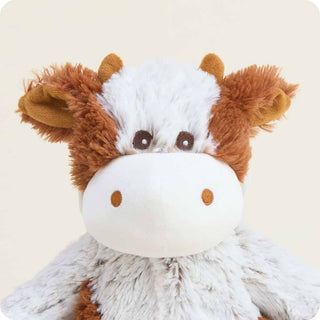 Cinnamon Latte Cow Warmies
Plush cow toy with brown and white fur on a beige background