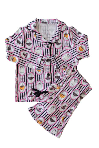 Caden Lane Girl's Two Piece Flare Lounge Set - Glow in the Dark Galloween
A children's pajama set with a Halloween theme, featuring a short-sleeve button-up top and matching shorts. The fabric has a white base with black vertical stripes, pink circular borders, and illustrations of bats, ghosts, pumpkins, and a witch's hat.
