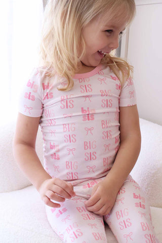 Caden Lane Two Piece Pajama Set - Big Sis Bows
Child wearing a pink 'BIG SIS' pajama set sitting on a white surface.