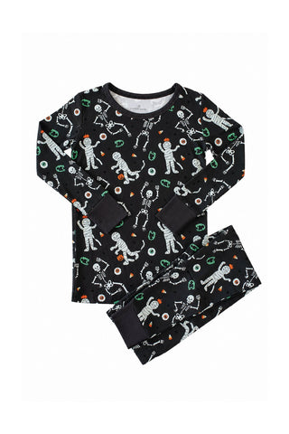 Caden Lane Two Piece Pajama Set - Glow in the Dark Eye Want Candy
A two-piece children's pajama set featuring a long-sleeve top and matching pants in black, decorated with a playful all-over print of white astronauts, skeletons, and small orange and green accents, laid flat against a white background.