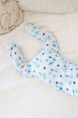 Caden Lane Zipper Footie - Little Bro Stars
Baby outfit with blue patterns on a textured beige surface