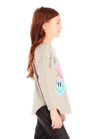 Chaser Colorful Smileys Long Sleeve
Girl wearing a gray long-sleeve shirt with colorful smiley face designs on a white background