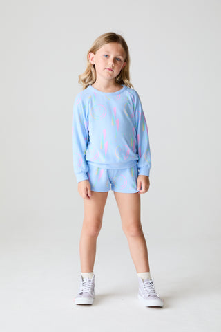 Chaser Lightning Smile Long Sleeve
Young girl wearing a light blue sweatshirt and shorts set on a white background