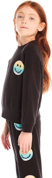 Chaser Pastel Rainbow Smiley Pullover
Child wearing a black outfit with smiley face designs on a plain background