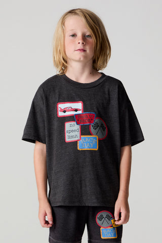 Chaser Race Patches Tee
Child wearing a dark gray t-shirt with colorful patches on a plain background