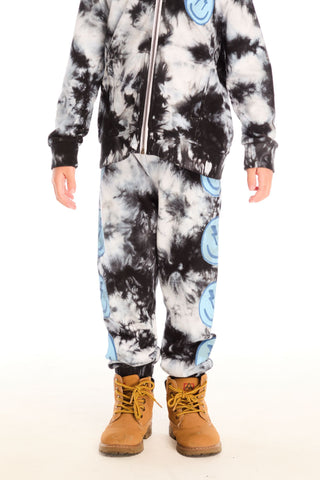 Chaser Smiley Bolt Pants
Person wearing a tie-dye onesie with blue accents on a white background