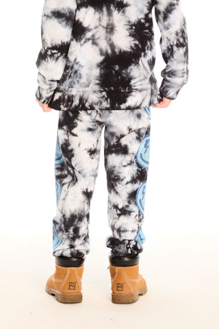 Chaser Smiley Bolt Pants
Person wearing a tie-dye hoodie and pants with brown boots on a white background