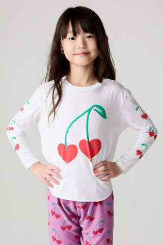 Chaser Sweethearts Girls Tee
Young girl wearing a white long-sleeve shirt with cherry design and pink pants with heart pattern on a light gray background