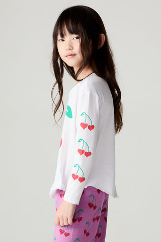 Chaser Sweethearts Girls Tee
Young girl wearing a white long-sleeve shirt with cherry designs and pink pants with red cherries on a plain background