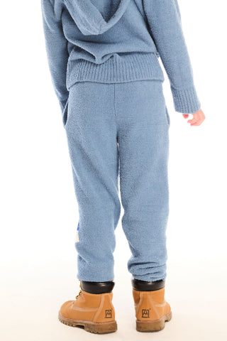 Chaser Tahoe Blue Lounge Pant With Pocket
Person wearing a blue knit outfit with brown boots on a white background
