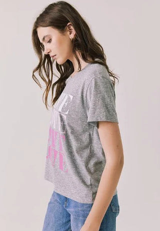 Chaser Women's Love Tee
Woman wearing a gray t-shirt with pink text on a plain background