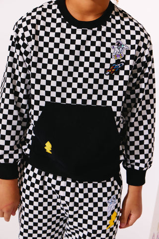 Lola and The Boys Checker Astro Patch Set
Person wearing a black and white checkered outfit with a logo on the chest.