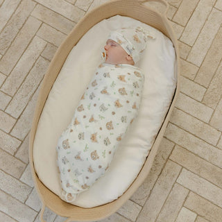 Copper Pearl Wilder Swaddle Blanket
Newborn baby swaddled in a floral blanket in a beige bassinet on a stone floor.